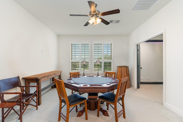 dining space with light carpet and ceiling fan