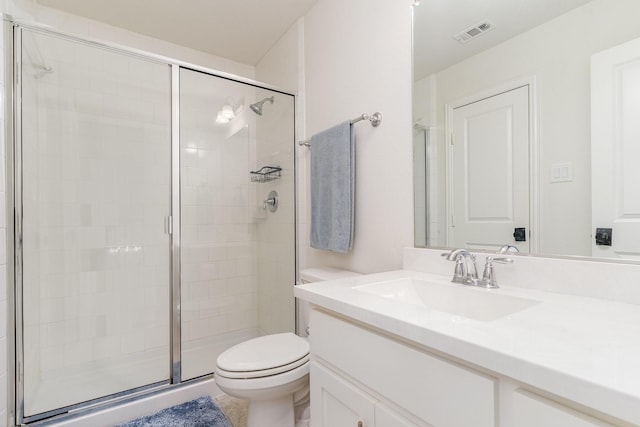 bathroom featuring vanity, toilet, and a shower with shower door