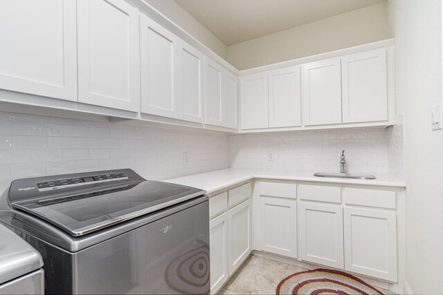 washroom featuring cabinets, light tile patterned floors, washer / clothes dryer, and sink