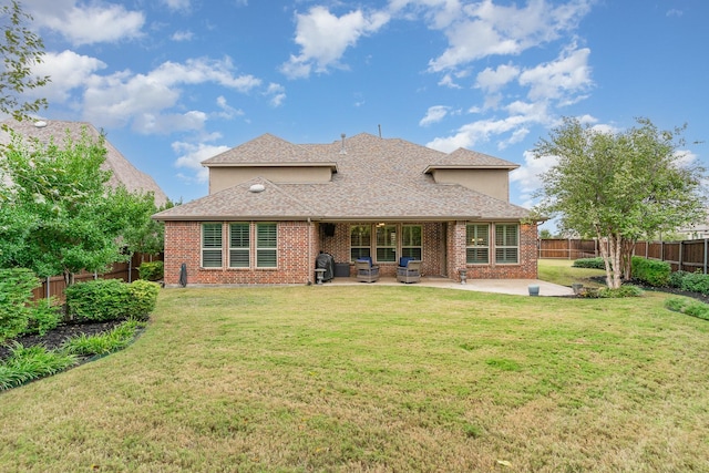 rear view of house with a yard and a patio