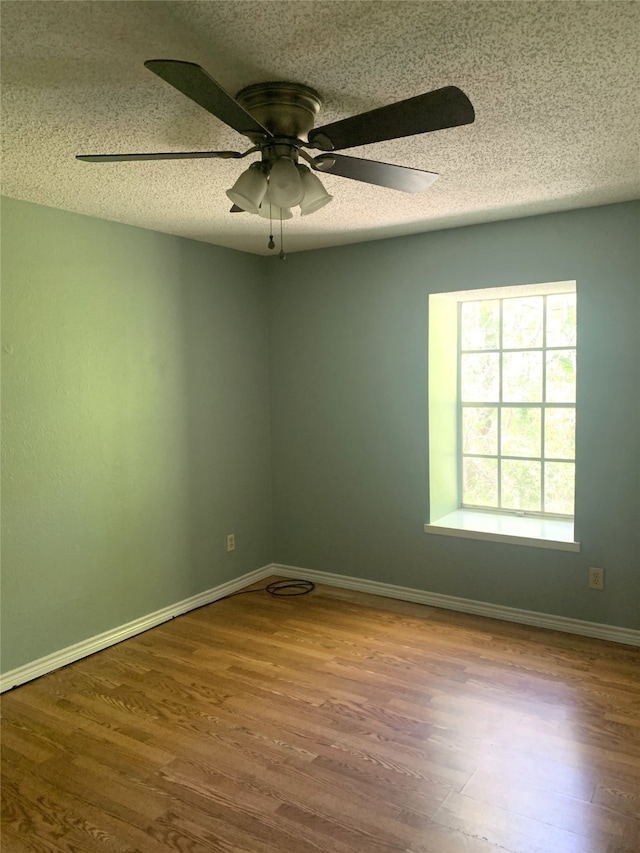 unfurnished room featuring ceiling fan, wood-type flooring, and a textured ceiling