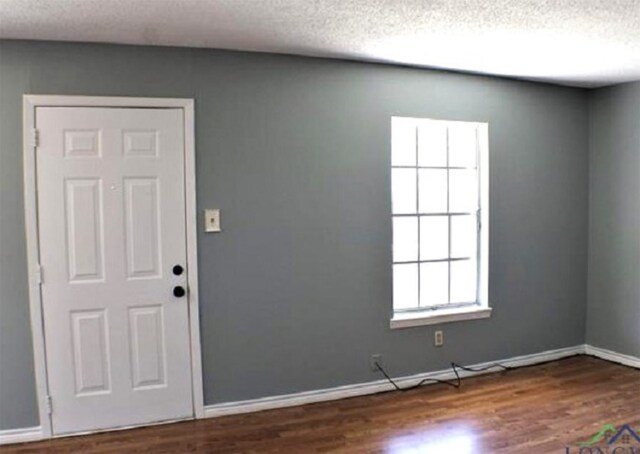 entrance foyer with dark hardwood / wood-style floors and a textured ceiling