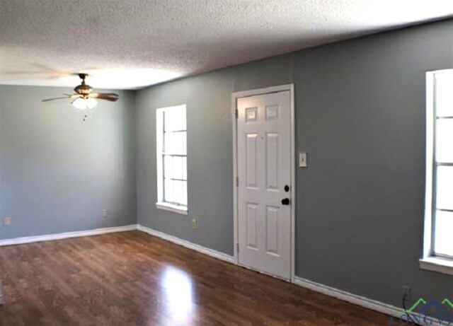 foyer with dark hardwood / wood-style flooring, a textured ceiling, and ceiling fan