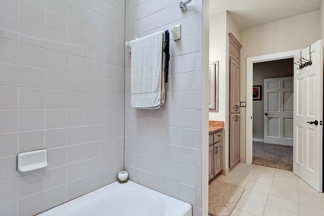 bathroom featuring tile patterned flooring, vanity, and  shower combination