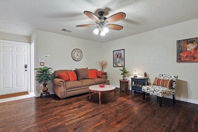 living room featuring a textured ceiling and ceiling fan