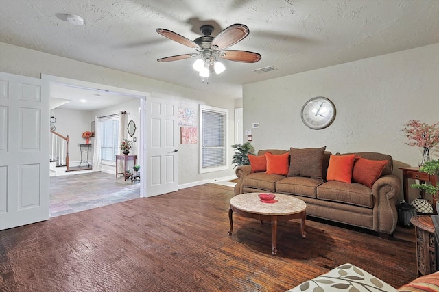 living room with hardwood / wood-style flooring, a textured ceiling, and ceiling fan