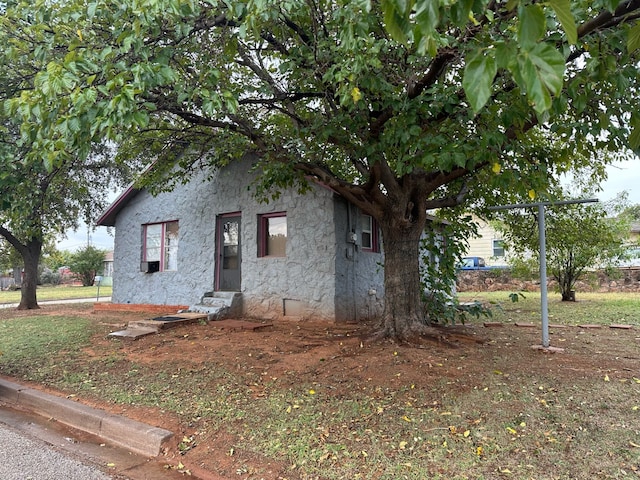 200 W Oklahoma Ave, Sweetwater, TX 79556 - view of side of home featuring entry steps, stone siding, and stucco siding