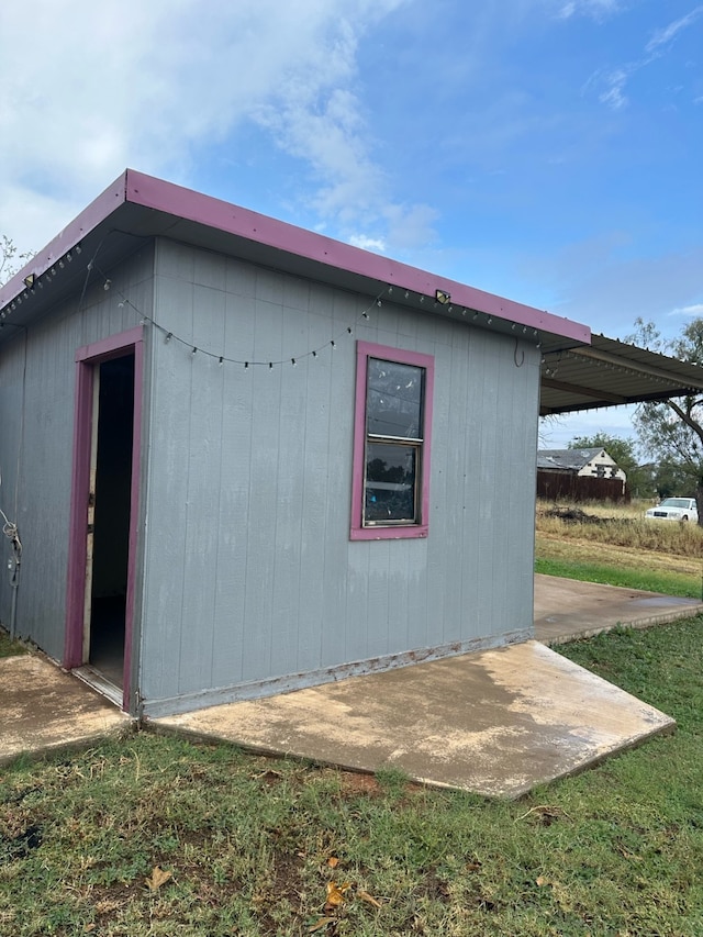 view of home's exterior with an outbuilding and a patio area