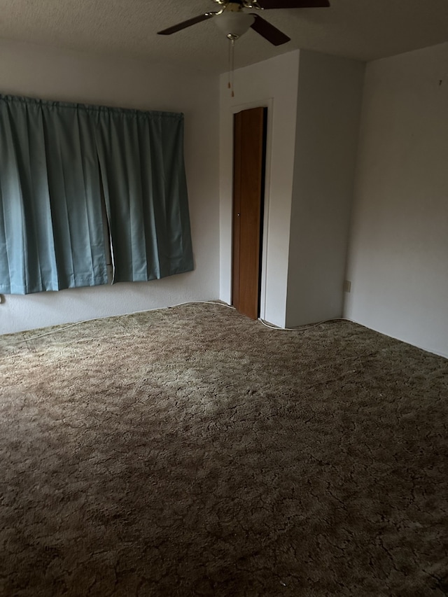 unfurnished room featuring a textured ceiling, carpet flooring, and ceiling fan