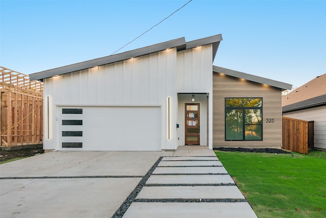 contemporary house with a front yard and a garage