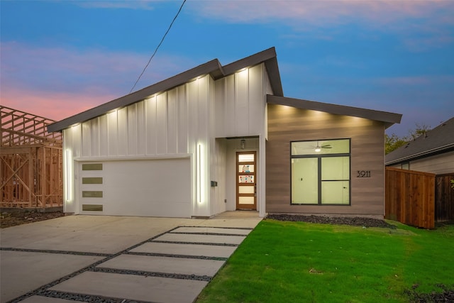 contemporary home featuring a garage and a lawn