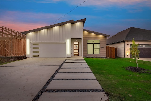 contemporary home featuring a garage and a lawn