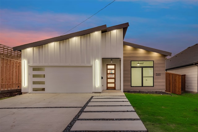 contemporary home featuring a garage and a yard