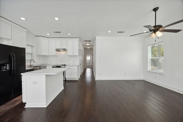 kitchen with electric range, a kitchen island, dark hardwood / wood-style flooring, black fridge with ice dispenser, and white cabinets