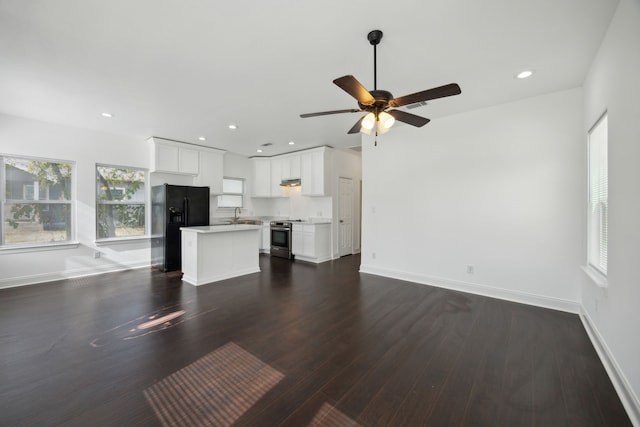 unfurnished living room with dark hardwood / wood-style floors, ceiling fan, and sink