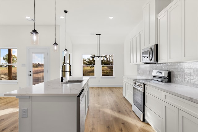 kitchen featuring a center island with sink, sink, white cabinets, and stainless steel appliances