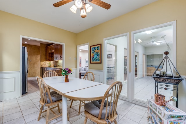 dining room with light tile patterned flooring, ceiling fan, and sink