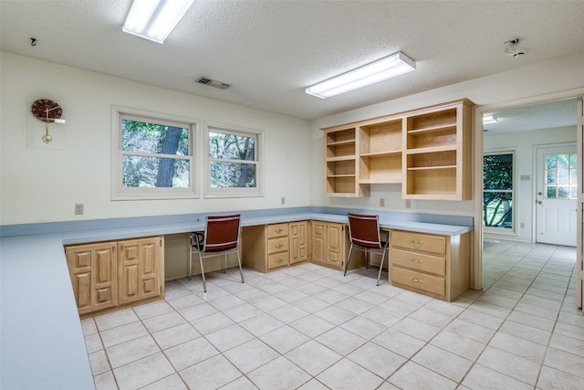 tiled office with built in desk and a textured ceiling