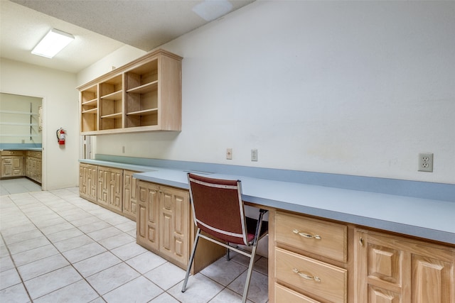 office space with built in desk and light tile patterned floors