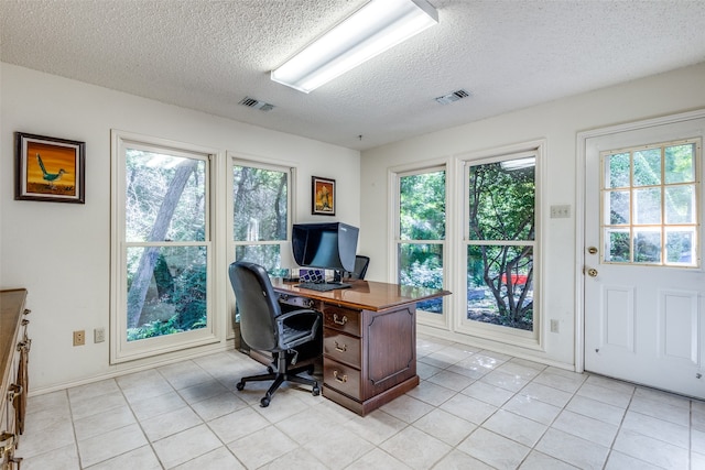 tiled office space featuring a textured ceiling