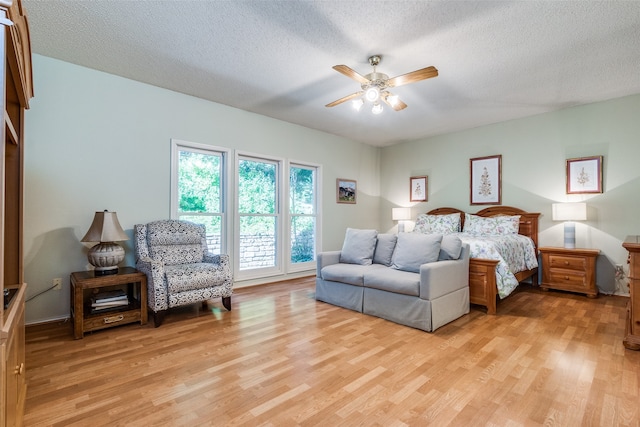 bedroom featuring a textured ceiling, light hardwood / wood-style floors, and ceiling fan