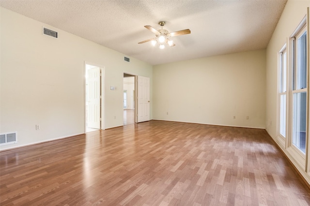 spare room with ceiling fan, visible vents, and wood finished floors