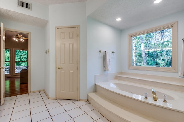 bathroom featuring visible vents, recessed lighting, a textured ceiling, tile patterned floors, and a bath