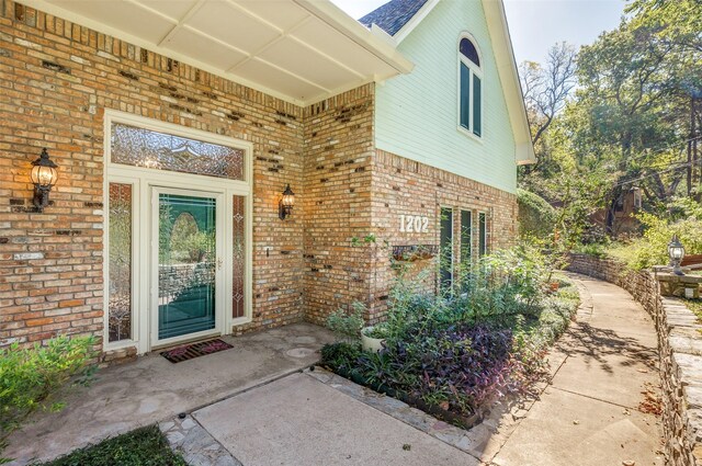 doorway to property with brick siding