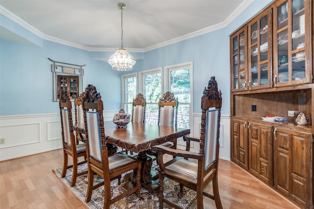 dining area featuring light hardwood / wood-style flooring, a chandelier, and crown molding