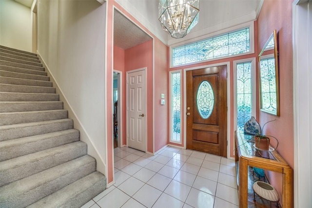 entryway featuring light tile patterned floors, stairway, baseboards, and a notable chandelier