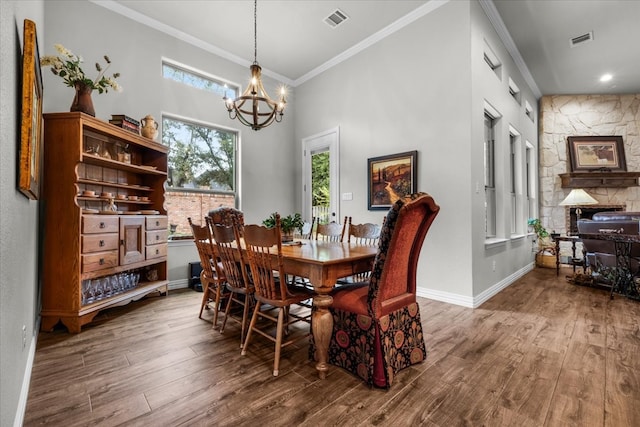 dining room with hardwood / wood-style flooring, a high ceiling, crown molding, and a notable chandelier