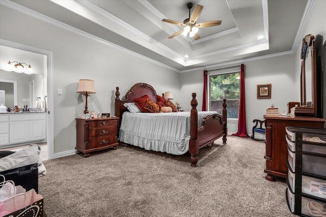 bedroom with ensuite bath, ornamental molding, a tray ceiling, and light carpet