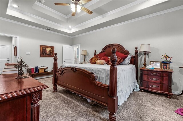 bedroom with ornamental molding, carpet floors, ceiling fan, and a tray ceiling