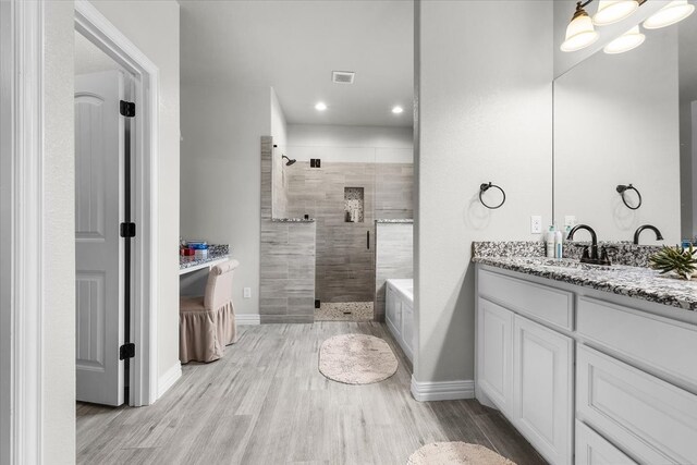 bathroom featuring vanity, an enclosed shower, and wood-type flooring