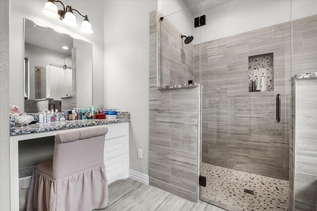 bathroom featuring vanity and a shower with door