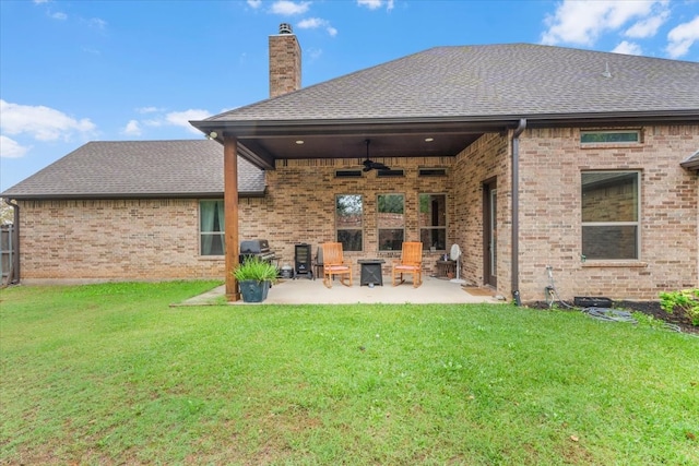 back of property with a patio area, a yard, and ceiling fan