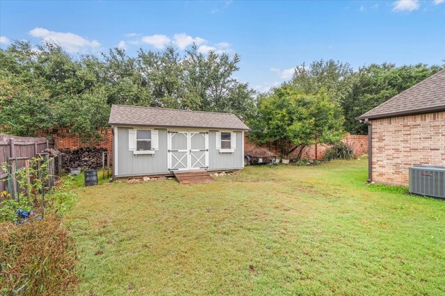 view of outdoor structure featuring central AC unit and a lawn