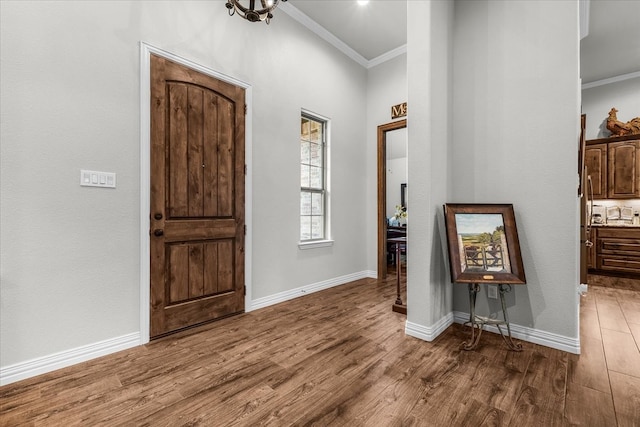 foyer entrance featuring hardwood / wood-style floors and crown molding