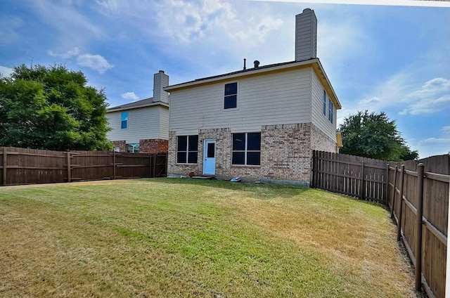 rear view of property with a yard