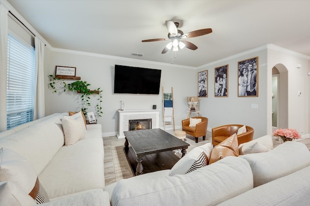 living room featuring ceiling fan, light hardwood / wood-style floors, and ornamental molding