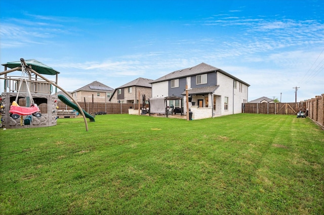 rear view of house with a playground and a yard