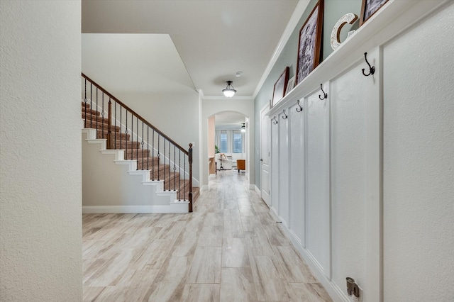 mudroom with crown molding and light hardwood / wood-style flooring