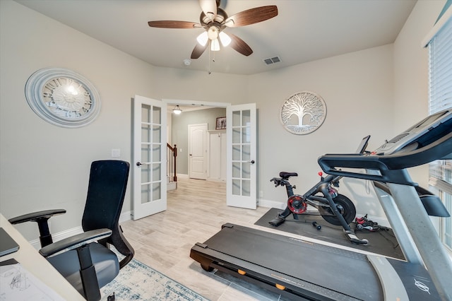 workout area featuring ceiling fan, light wood-type flooring, and french doors