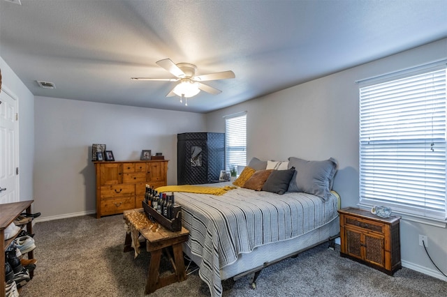 carpeted bedroom featuring ceiling fan and a textured ceiling