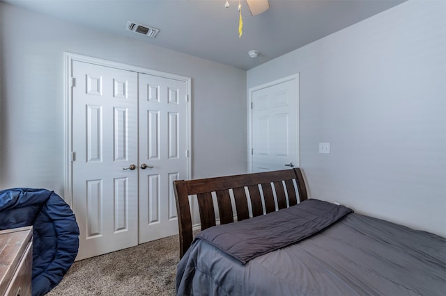 carpeted bedroom featuring ceiling fan and a closet