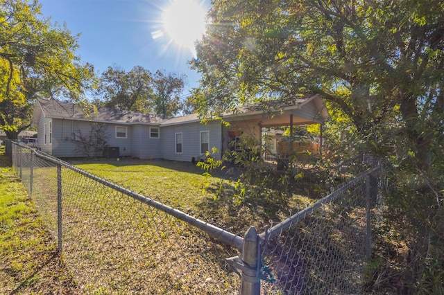 rear view of house with a yard and central AC unit