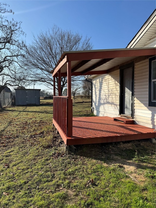 view of yard featuring a deck and a storage unit