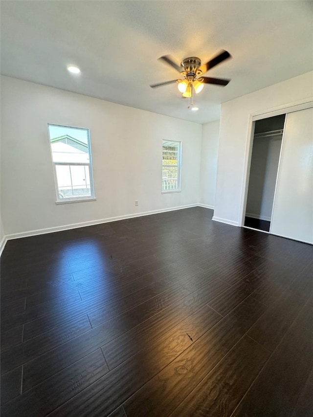 spare room with dark hardwood / wood-style floors and ceiling fan