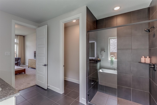 bathroom with tile patterned floors, plenty of natural light, plus walk in shower, and vanity