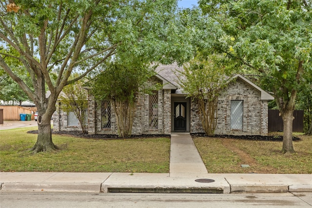 view of property hidden behind natural elements with a front yard